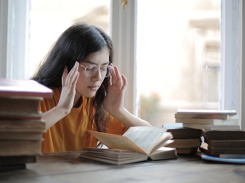 female-student-suffering-from-headache-in-library-3808057